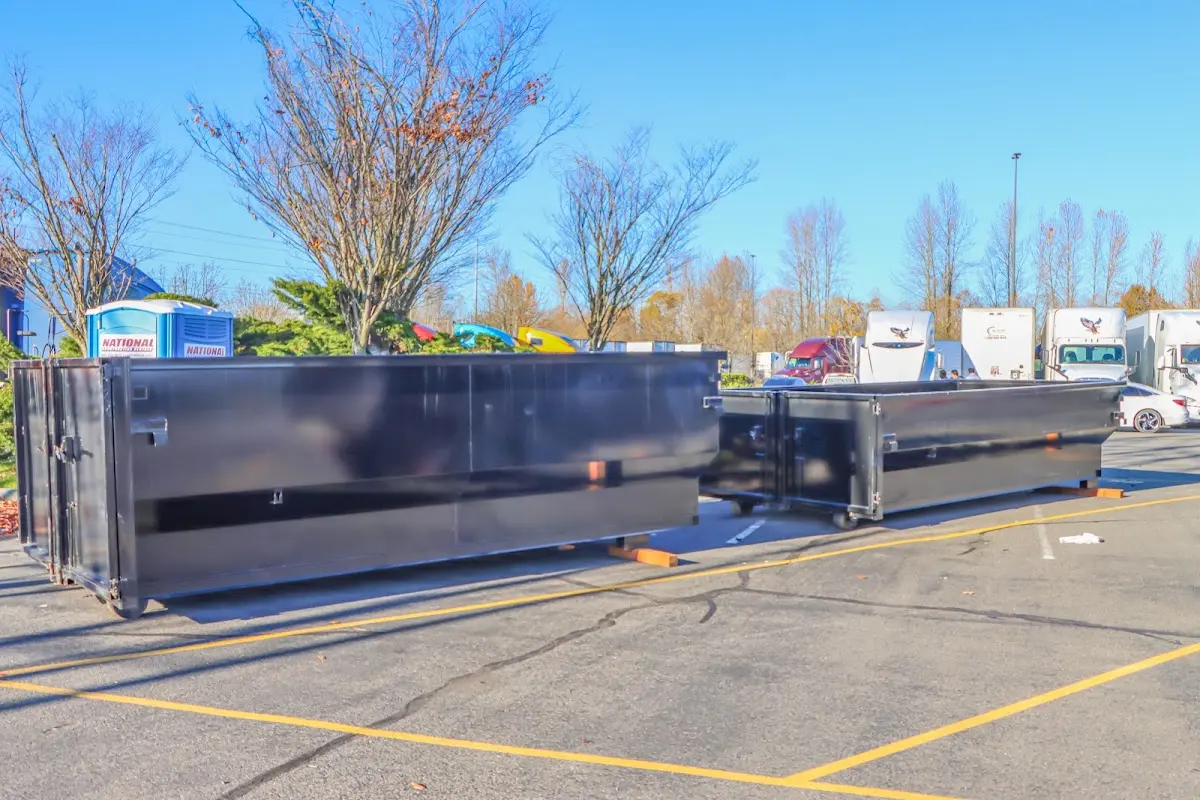 Professional dumpster rental service with roll-off container on residential driveway in Maple Grove